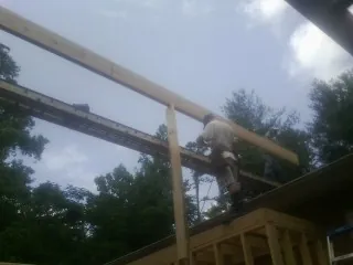 Carpenter setting a ridge beam over a new addition frame — Ice Dam Removal by Roofing Brothers in Atlasburg