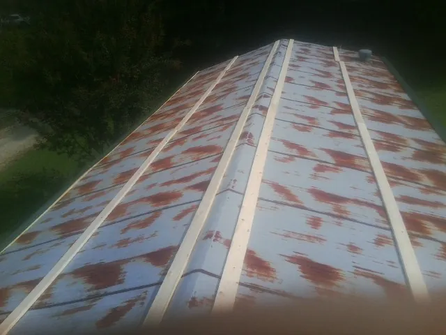 Rusted metal roof panels with new wood purlins before replacement — Storm Damage Roof Repair in Atlasburg by Roofing Brothers