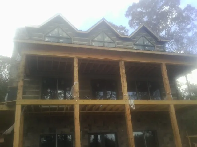 Dormers and porch framing on a large log home under construction — Roof Coating work by our crew in Atlasburg