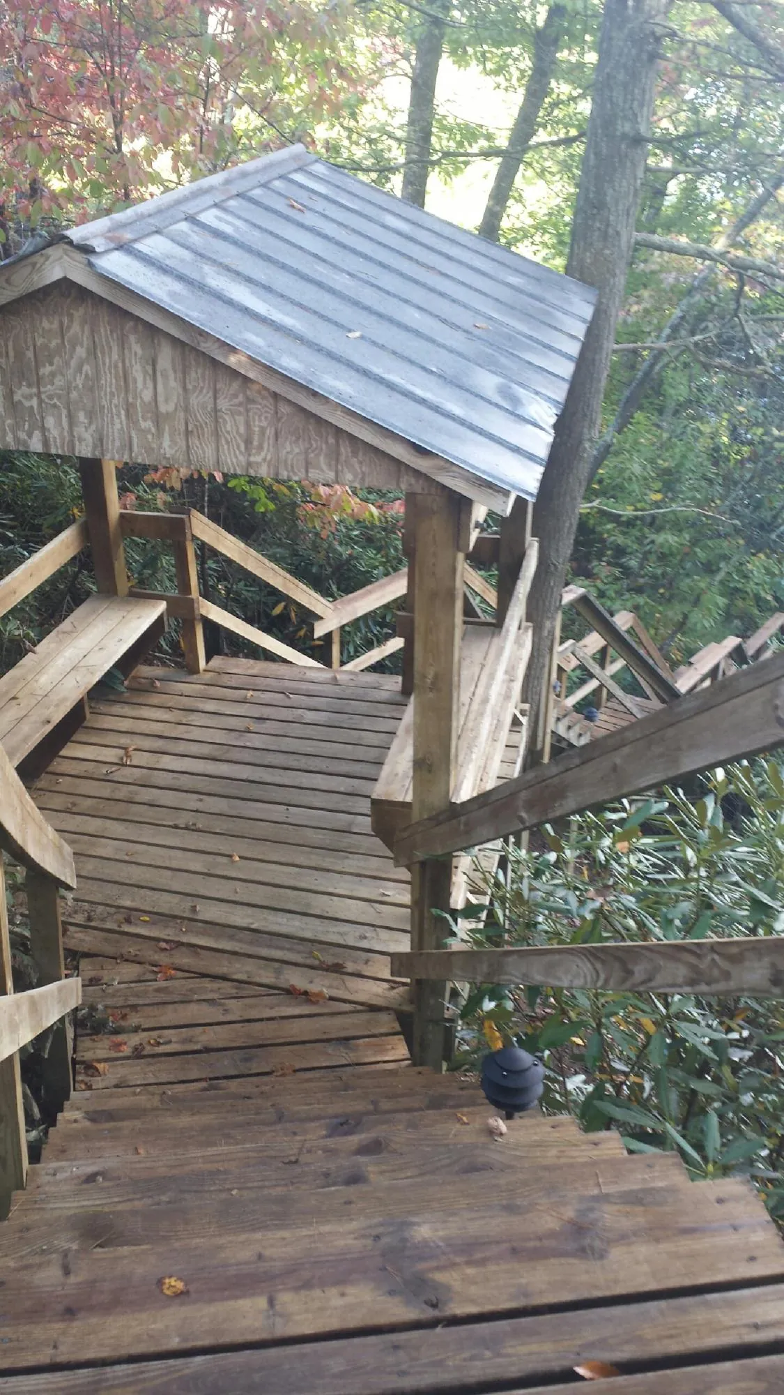 Metal roofed shelter over wooden steps on a wooded walkway — Skylight Repair & Installation work by our crew in Atlasburg