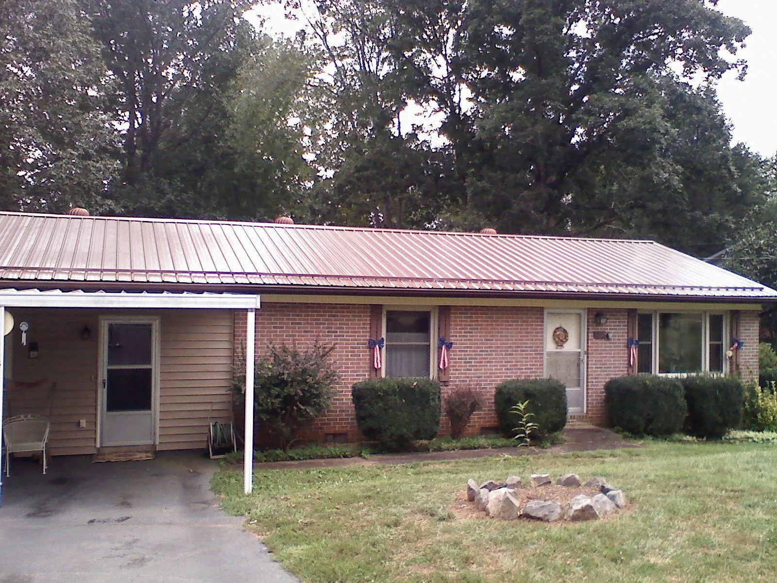 Bronze metal roof and carport on a brick ranch home — Roof Repair work by our crew in Atlasburg